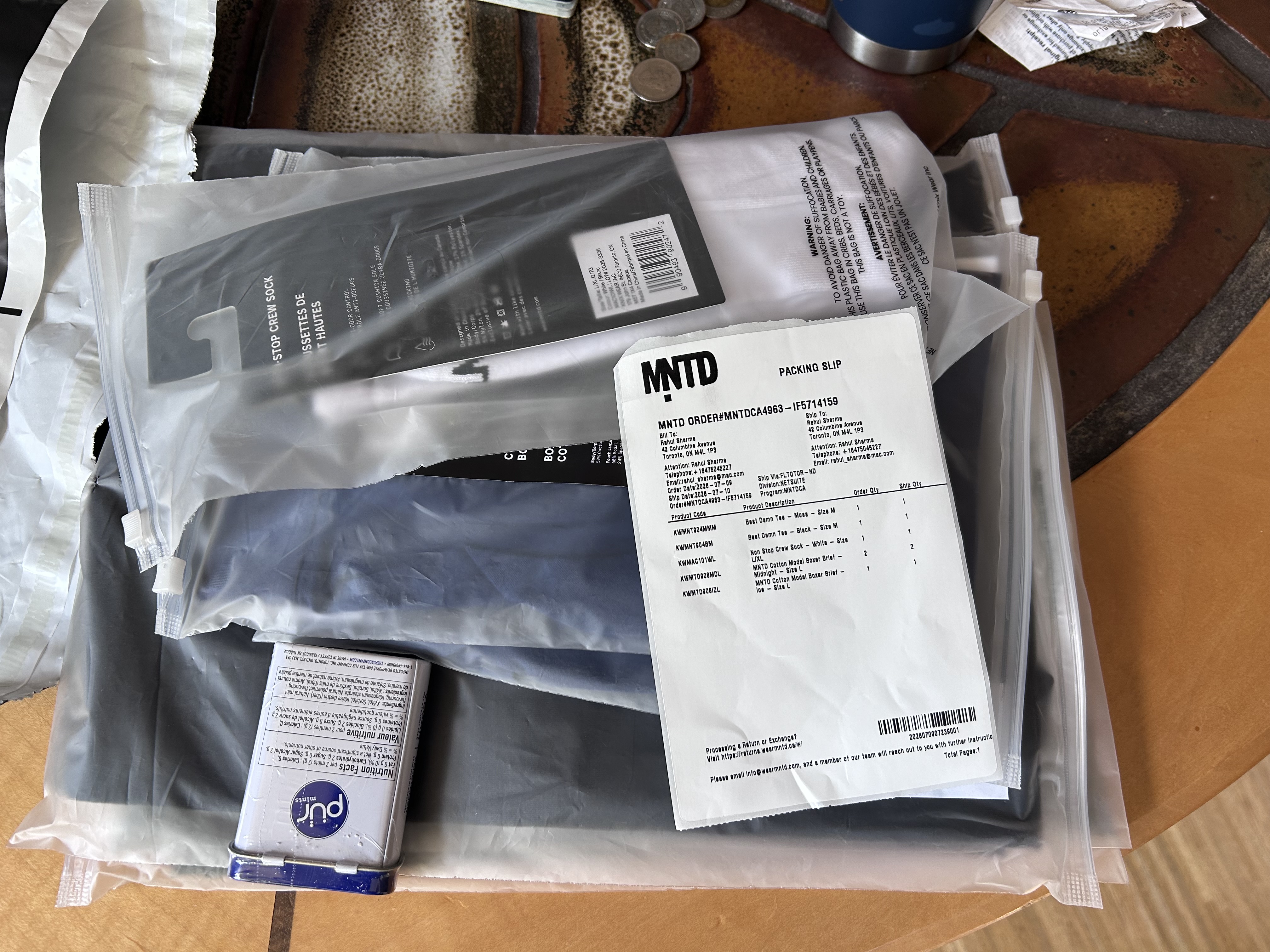Unboxed contents · MNTD packing slip for order MNTDCA4963-IF5714159, individually-bagged products (boxers, socks), Pur Mints tin gift, all laid out