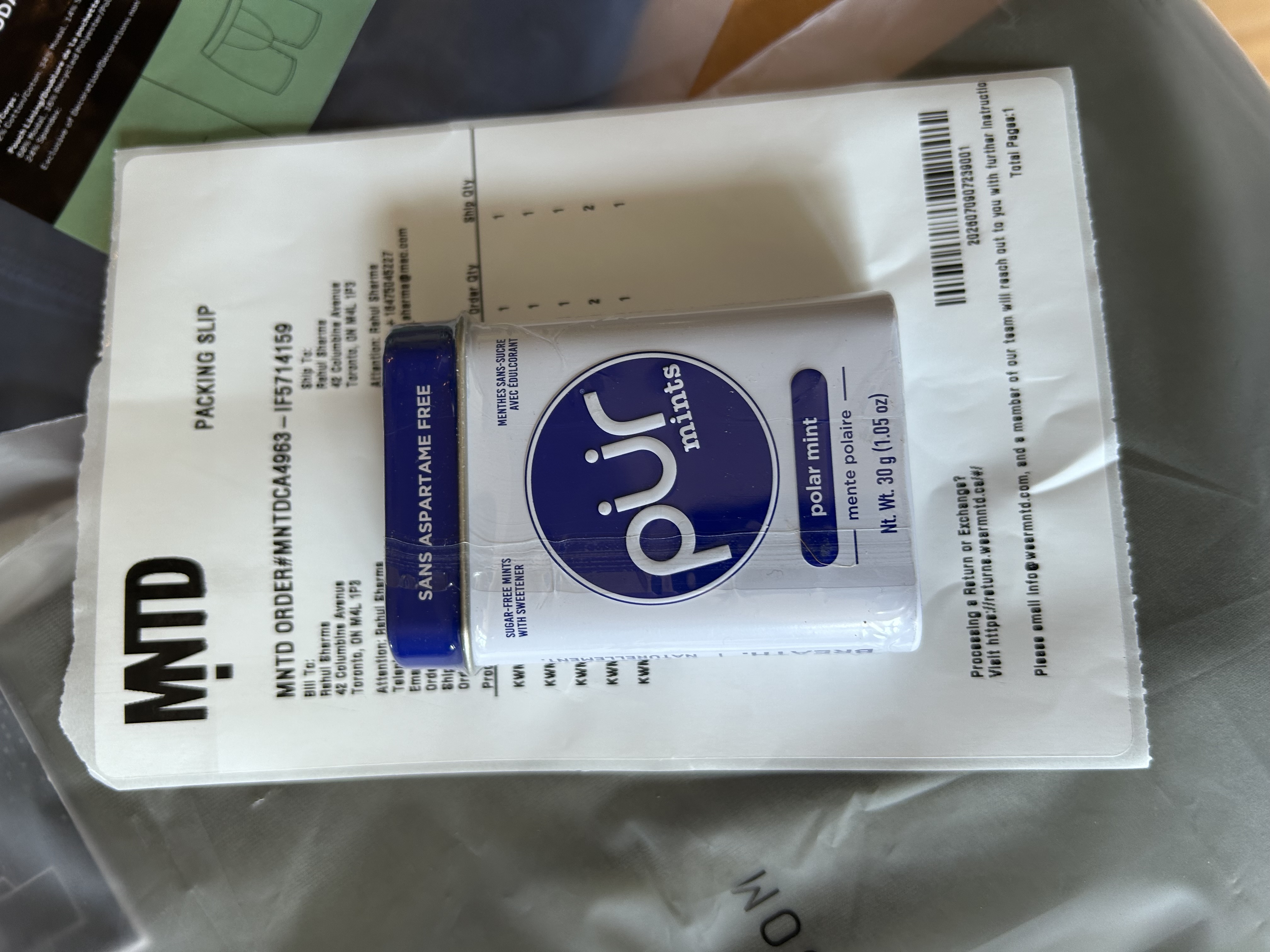 Pur Mints polar mint tin resting on the MNTD packing slip — unexpected small gift in the package